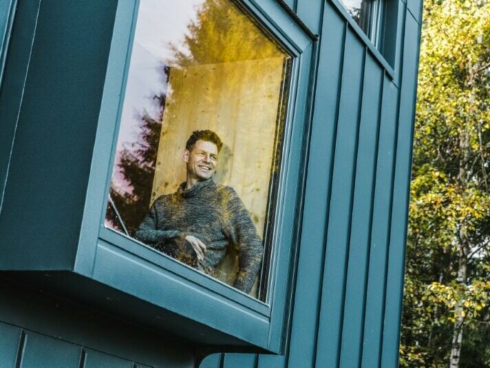Der Architekt sitzt in dem Ferienhaus in Tschechien am Fenster 