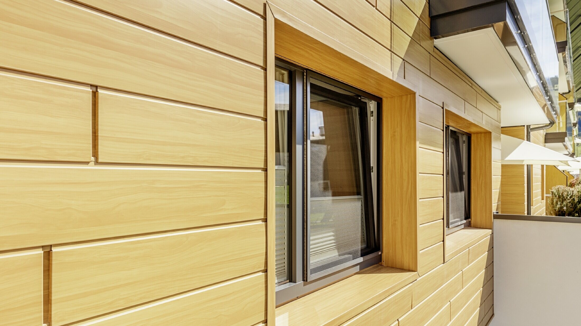 Detaljfoto av en vindusomramming med PREFA Siding med trelignende utseende på Guthof Lutz i Schattwald.