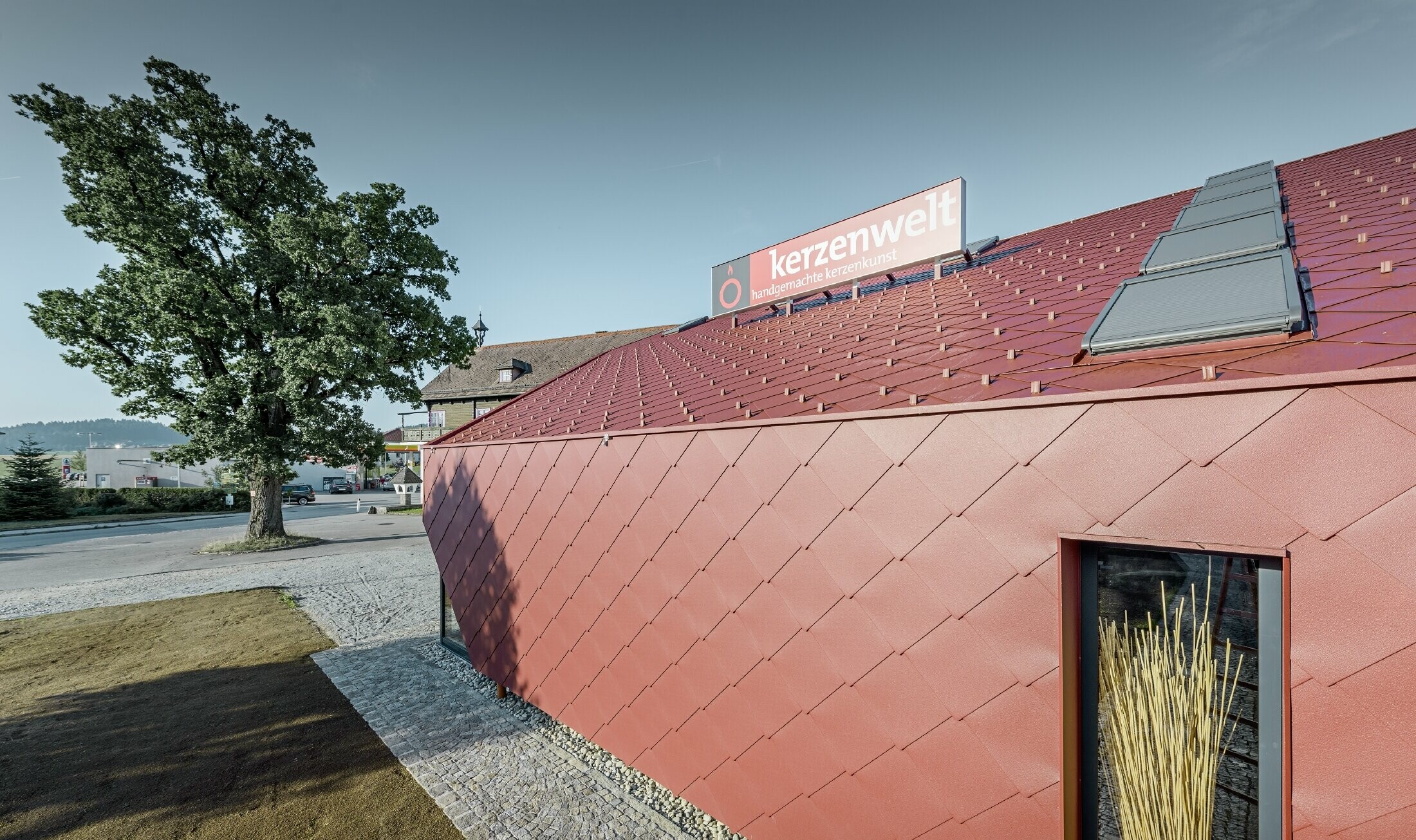 Kerzenwelt i Schlägl er kledd på nytt helt rundt med PREFA rombe. Takkledningen og fasadekledningen er utført med rombe 44 × 44 i oksydrød.