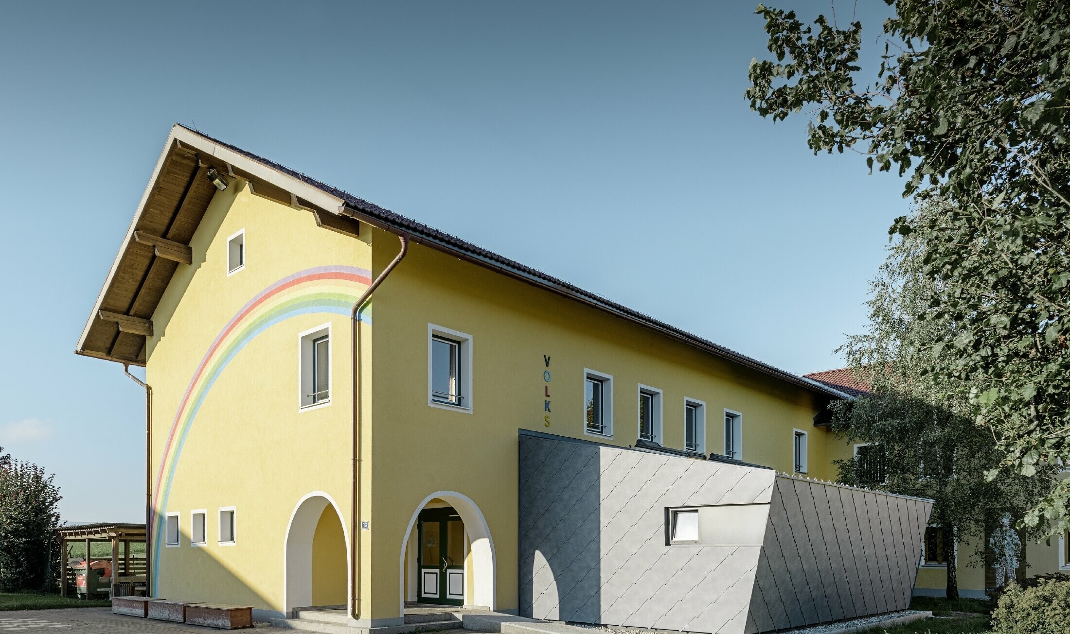 Zubau einer Volksschule eingedeckt mit der Dach- und Wandraute aus Aluminium von PREFA in steingrau