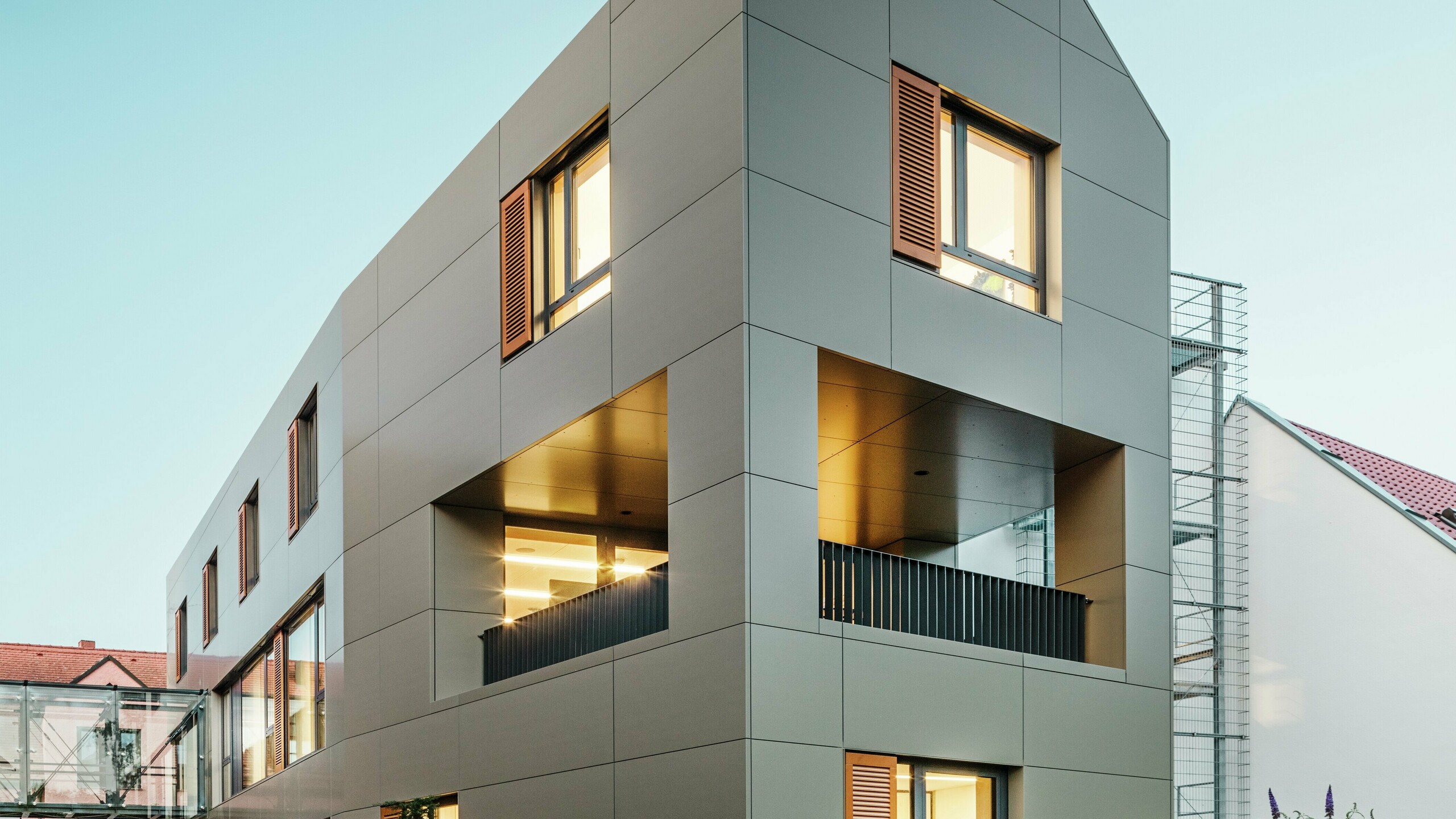 Gradska vijećnica u Alzenauu, Njemačka, ima modernu fasadu od aluminijskih kompozitnih ploča PREFA u brončanoj boji. Jasne, geometrijske linije ploča daju zgradi elegantan, suvremen izgled. Uređeni vanjski prostor nadopunjuje arhitekturu.