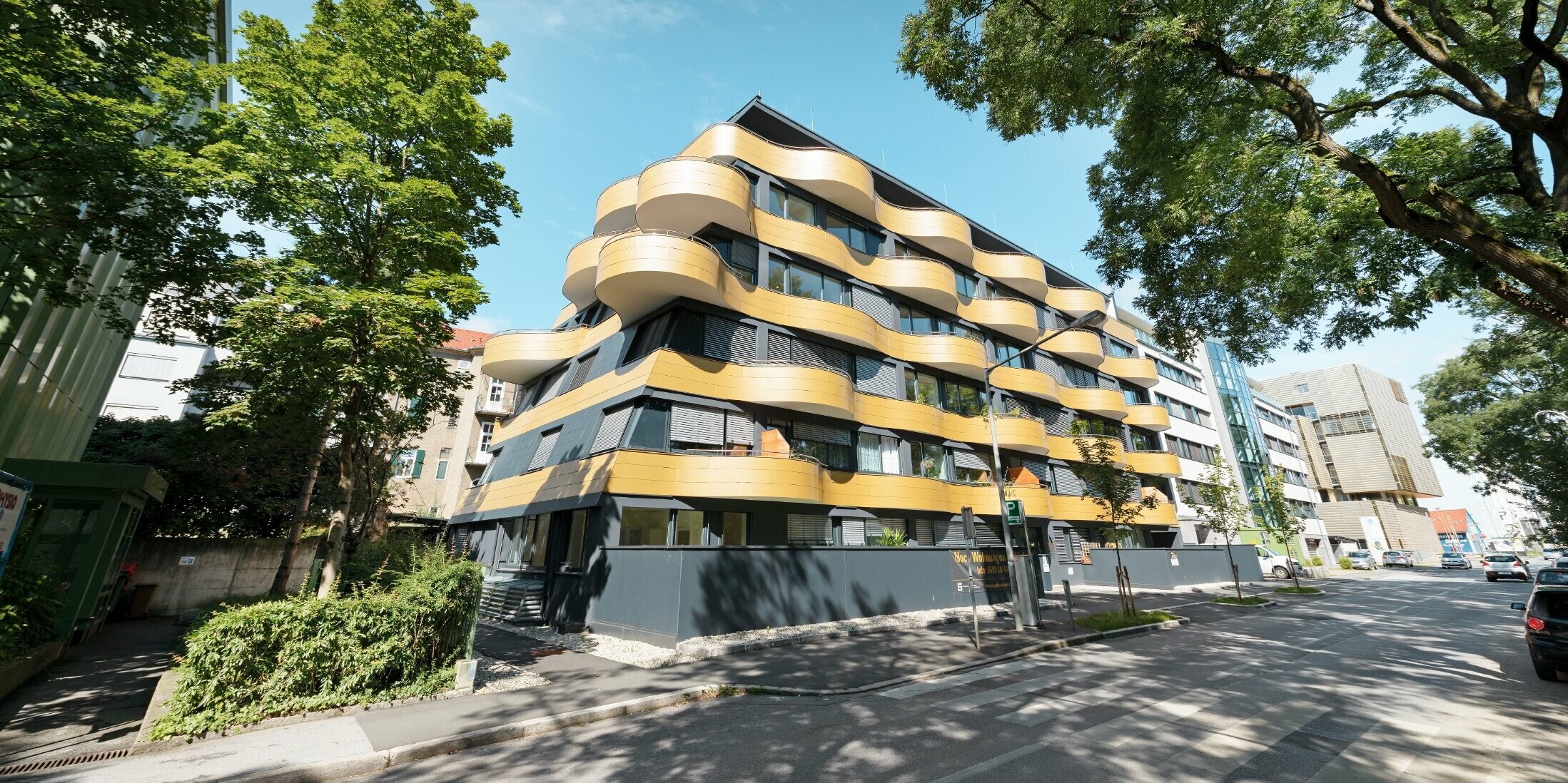 Boligområdet "Goldene Welle" i Graz, Østerrike, med aluminiumskomposittplate i gull, balkongene er avrundet i bølger 