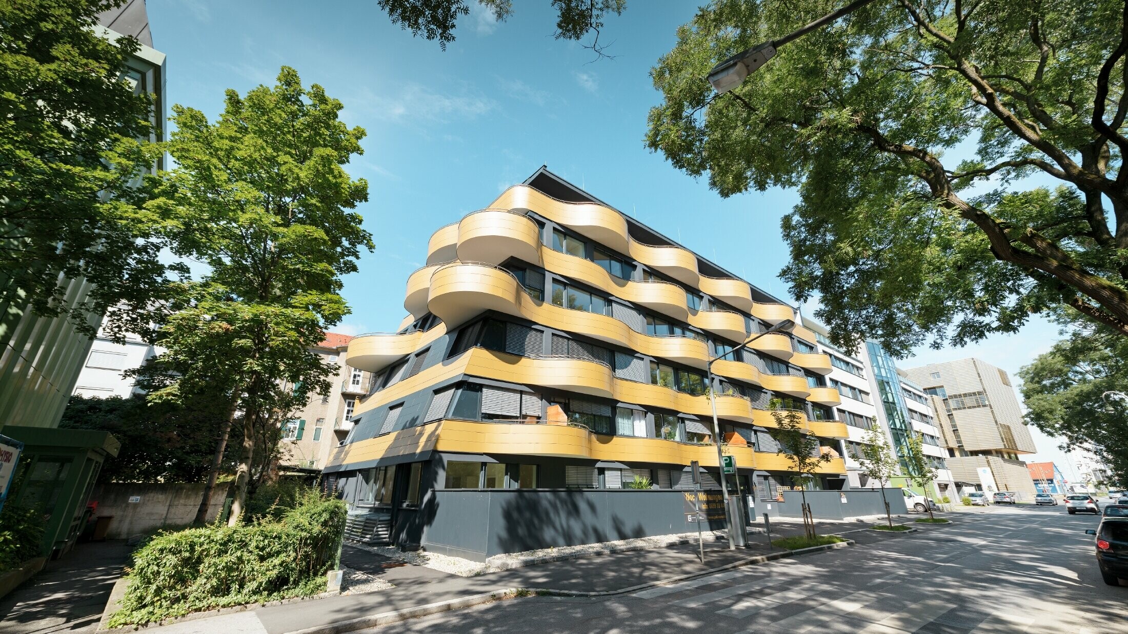 Boligområdet "Goldene Welle" i Graz, Østerrike, med aluminiumskomposittplate i gull, balkongene er avrundet i bølger 