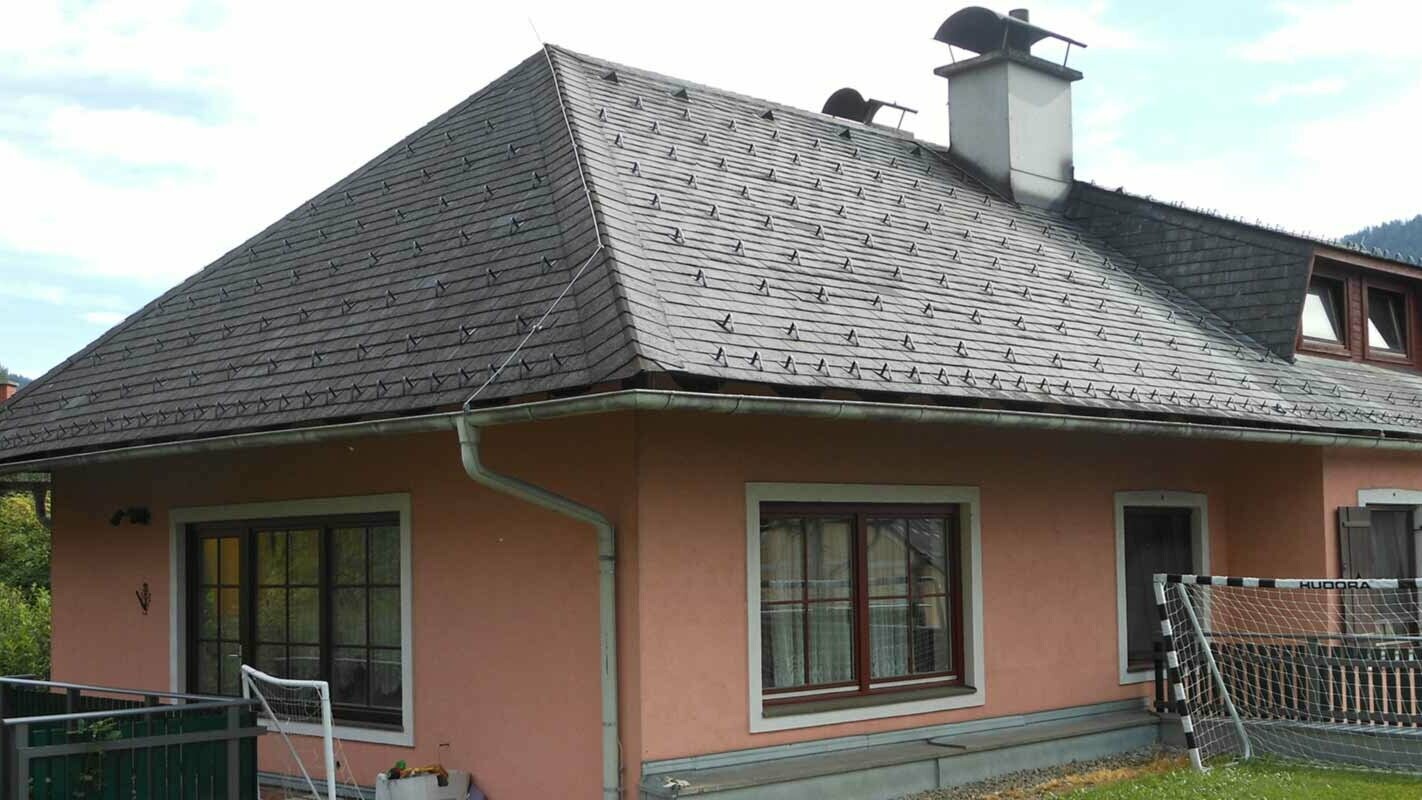Valmtak før renovering av taket på et hus med trapseformet kvist med bruk av PREFA takshingel
