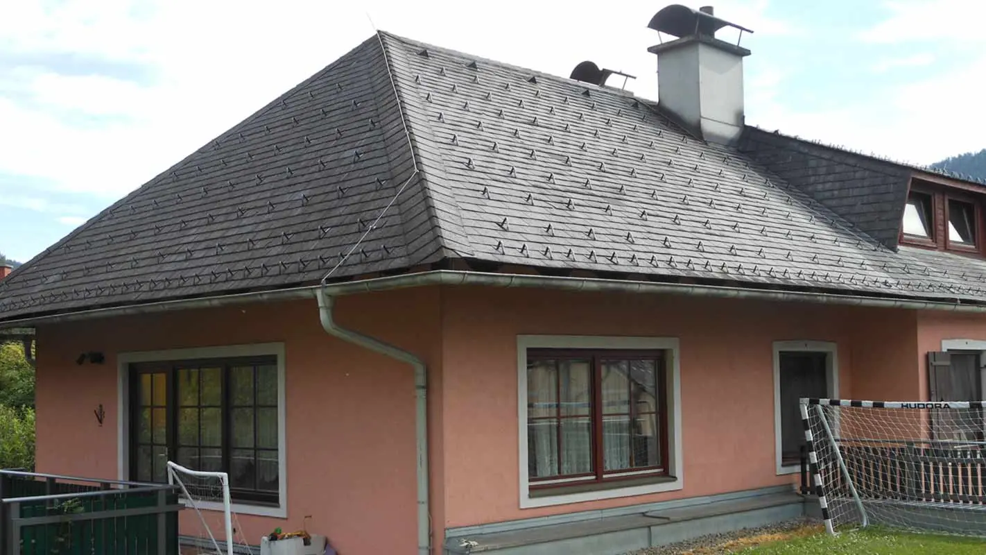 Valmtak før renovering av taket på et hus med trapseformet kvist med bruk av PREFA takshingel