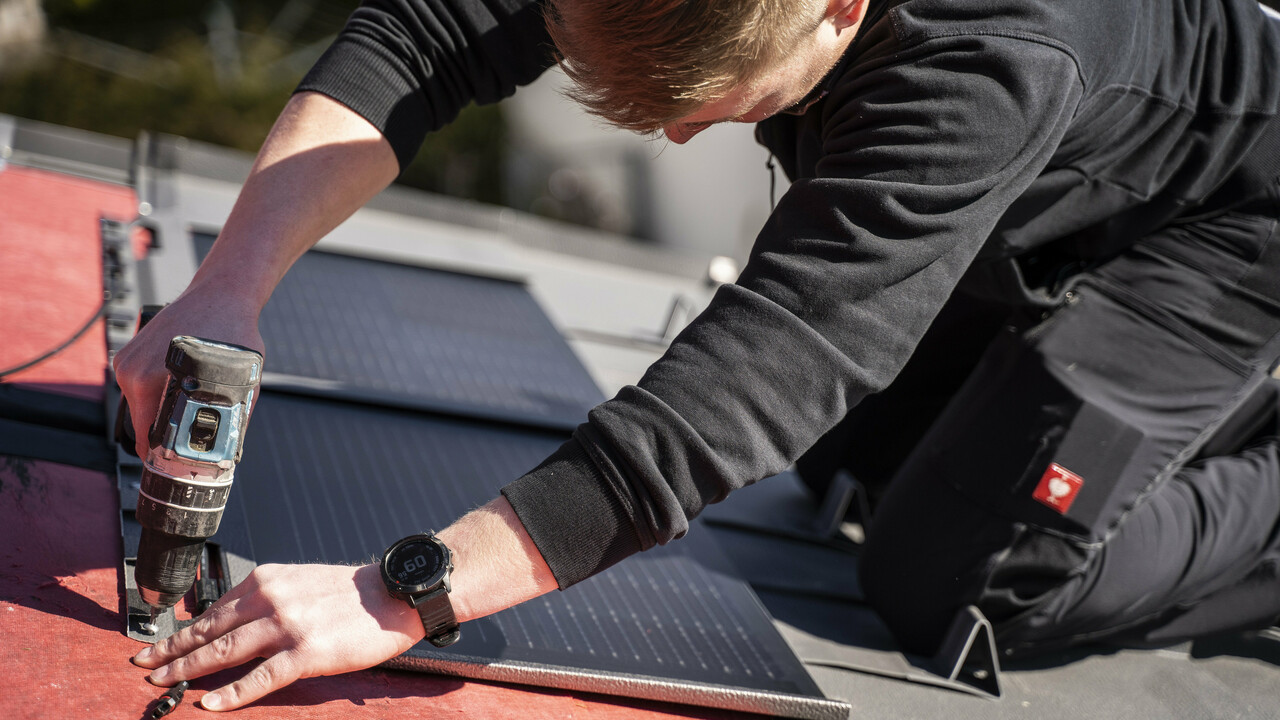 En PREFA-ansatt legger solcelle takplate.