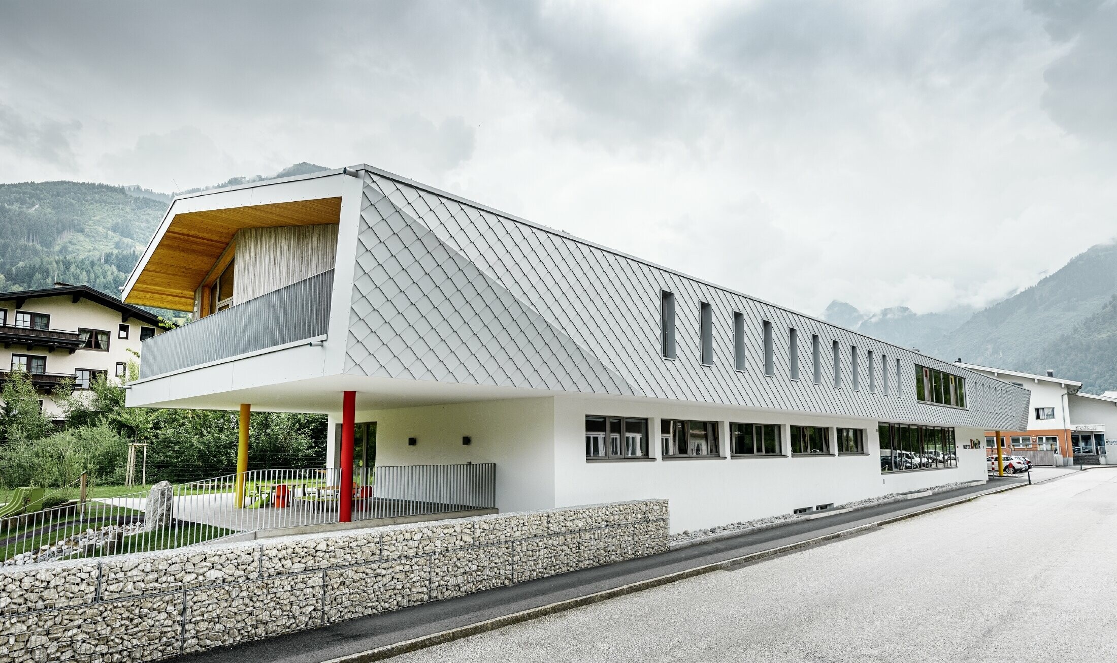 neu gebauter Kindergarten in Kaprun mit einer modernen Aluminium Fassade mit der PREFA Wandraute in prefaweiss